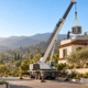 Crane setting a new AC condenser on the roof of a Glendale home during an AC installation